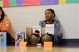 Photo of girl with book and pumpkins.